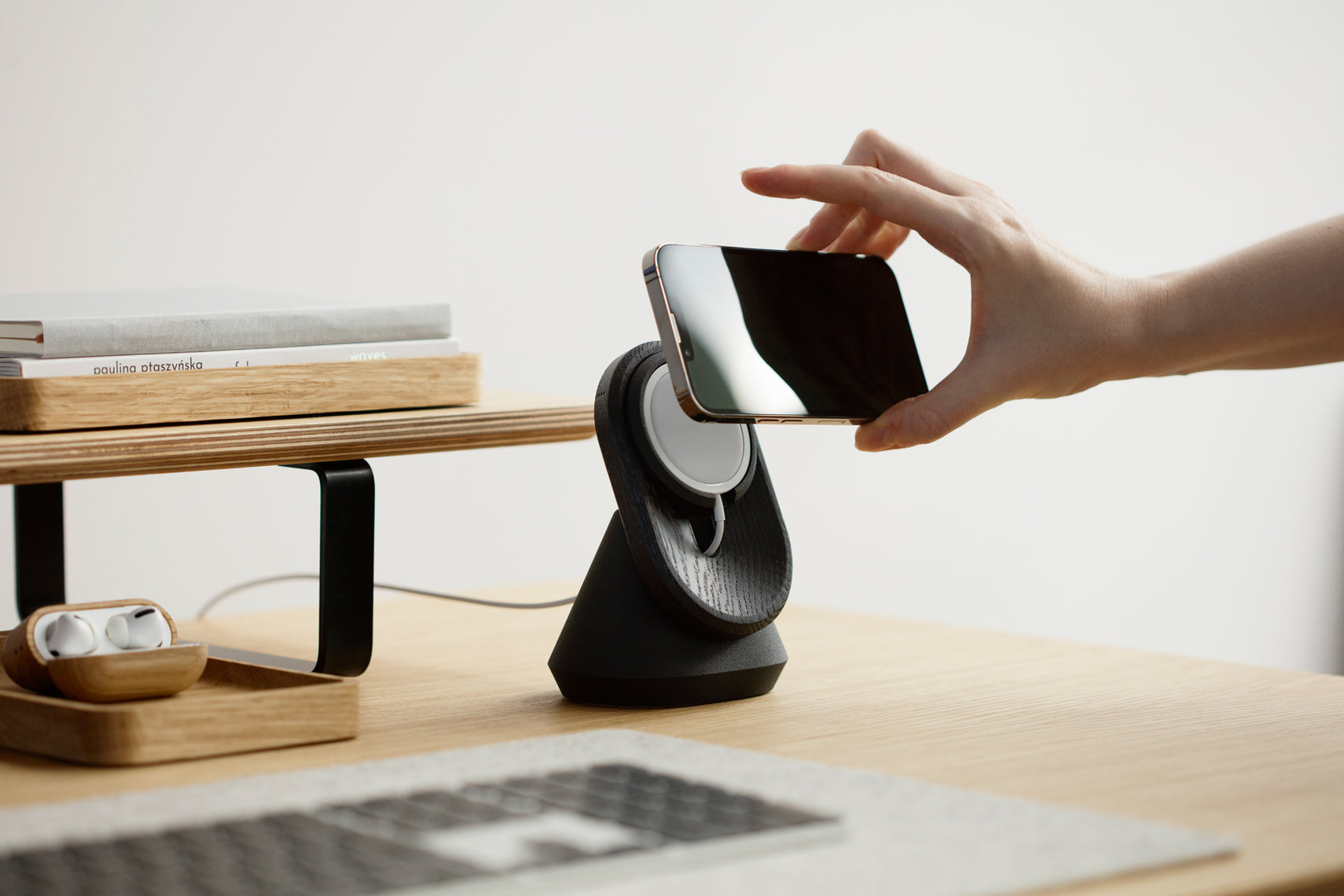 black magsafe iphone stand on a wooden desk | -